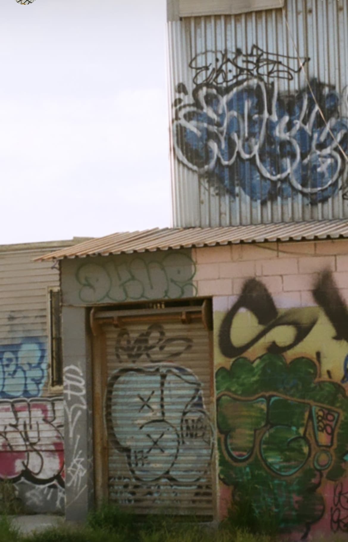 City's Edge: Graffiti and Green Awnings - Image 1